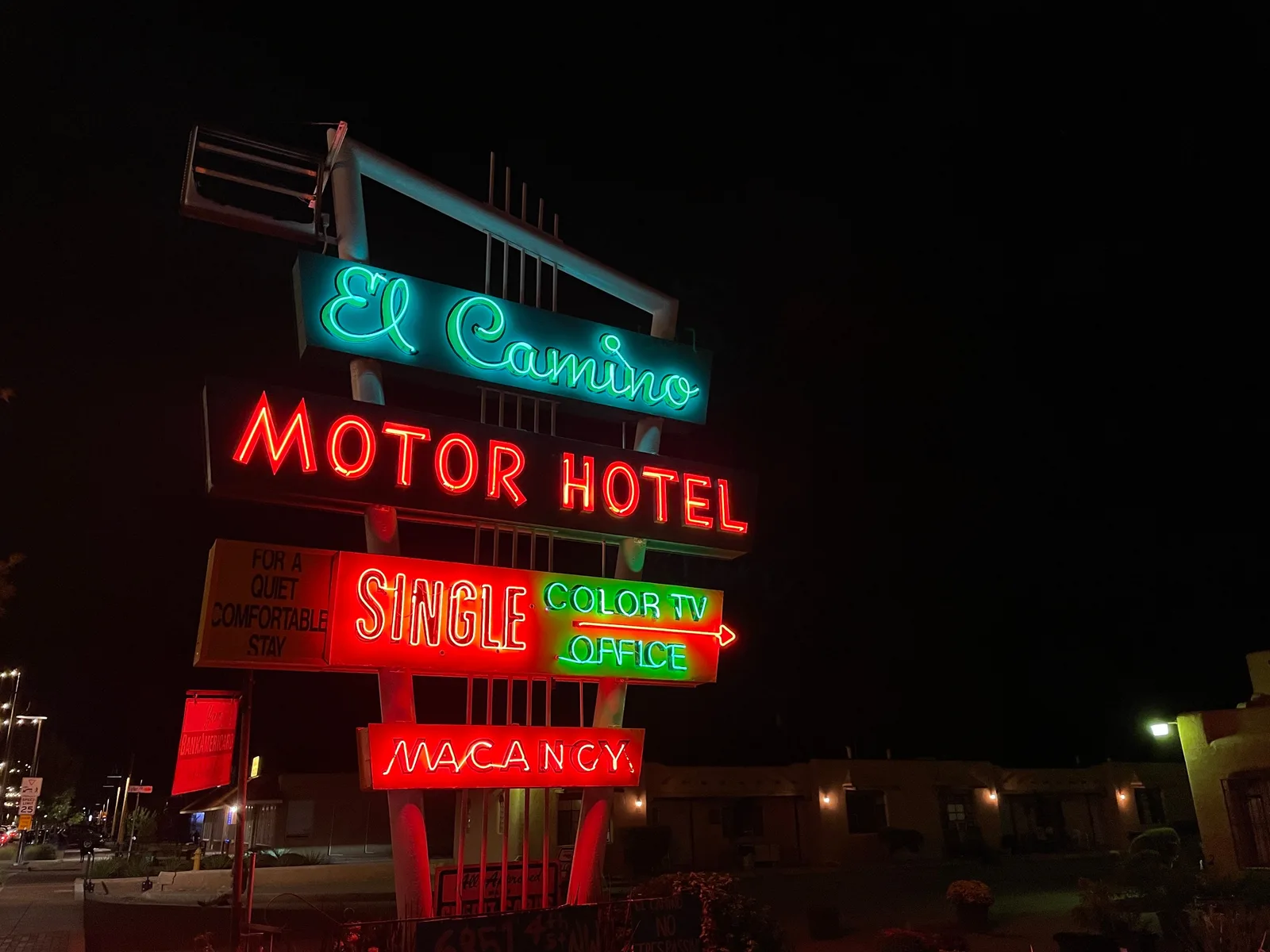 Colorful neon lights illuminate a vintage motel sign at night along the roadside. Historic Motel Restoration Steps Before Design Review