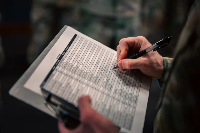 A clipboard with inspection notes is seen during a Standards and Readiness Review uniform inspection at Buckley Space Force Base, Colorado, March 21, 2025. Inspectors carefully documented observations to ensure service members met uniform standards. (U.S. Space Force photo by Senior Airman Joshua Ho. Read the Status Fields on a US Roadside Building Survey