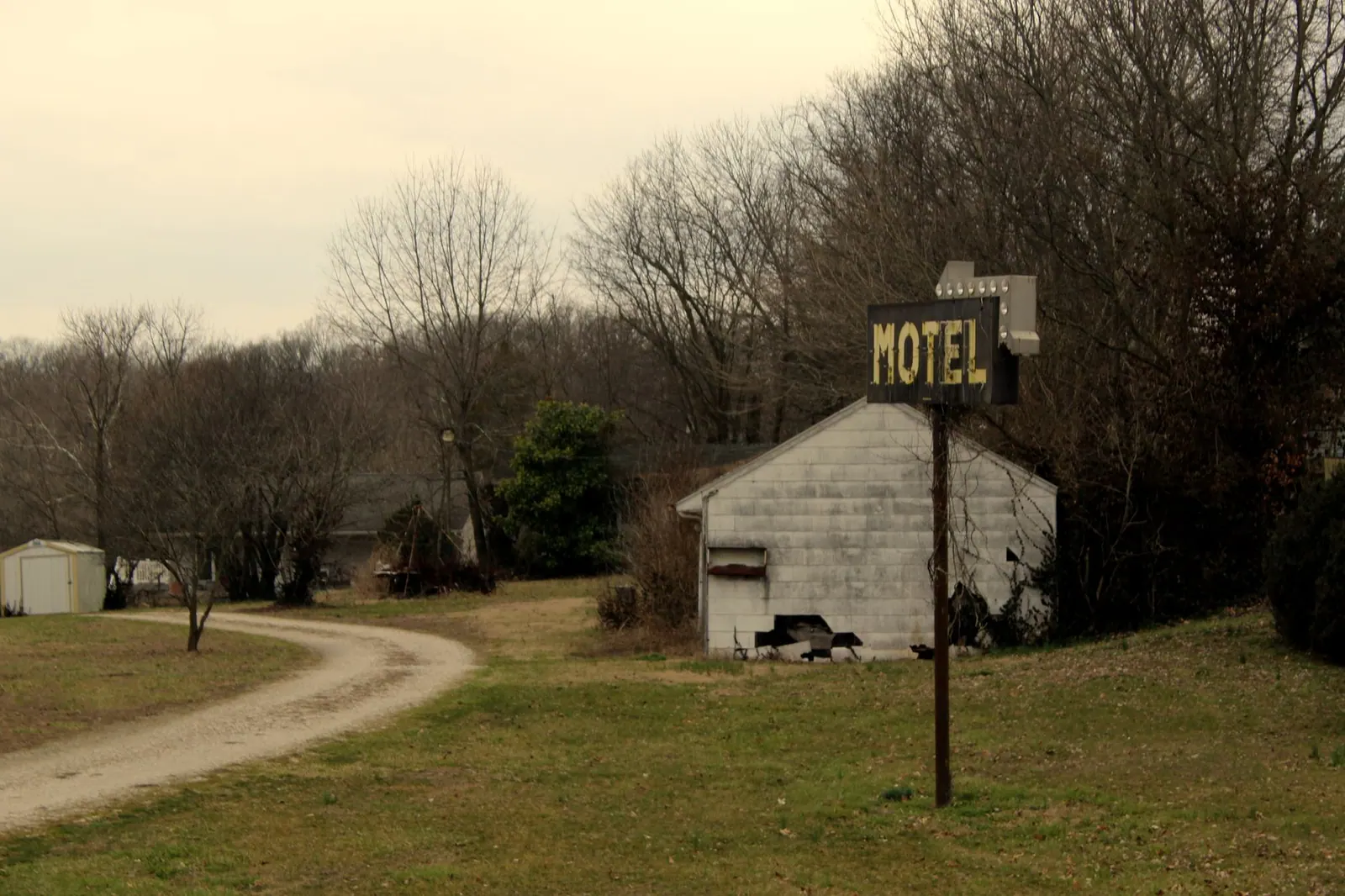 Old motel sign on a dirt road in rural Missouri, USA.