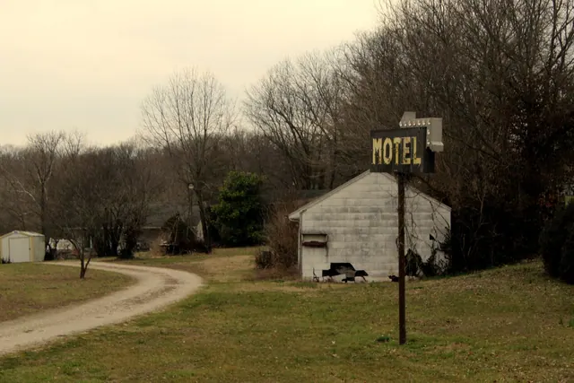 Old motel sign on a dirt road in rural Missouri, USA.